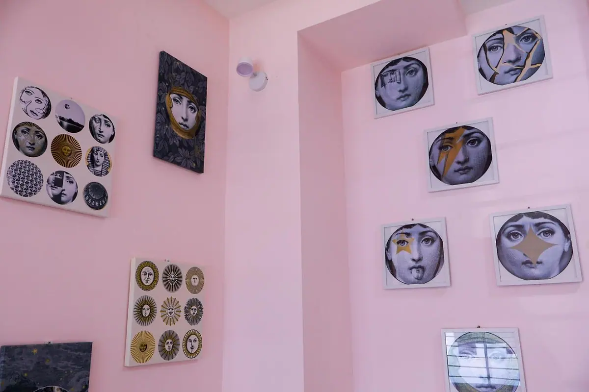 Face-plate artwork hung on the pink lounge wall