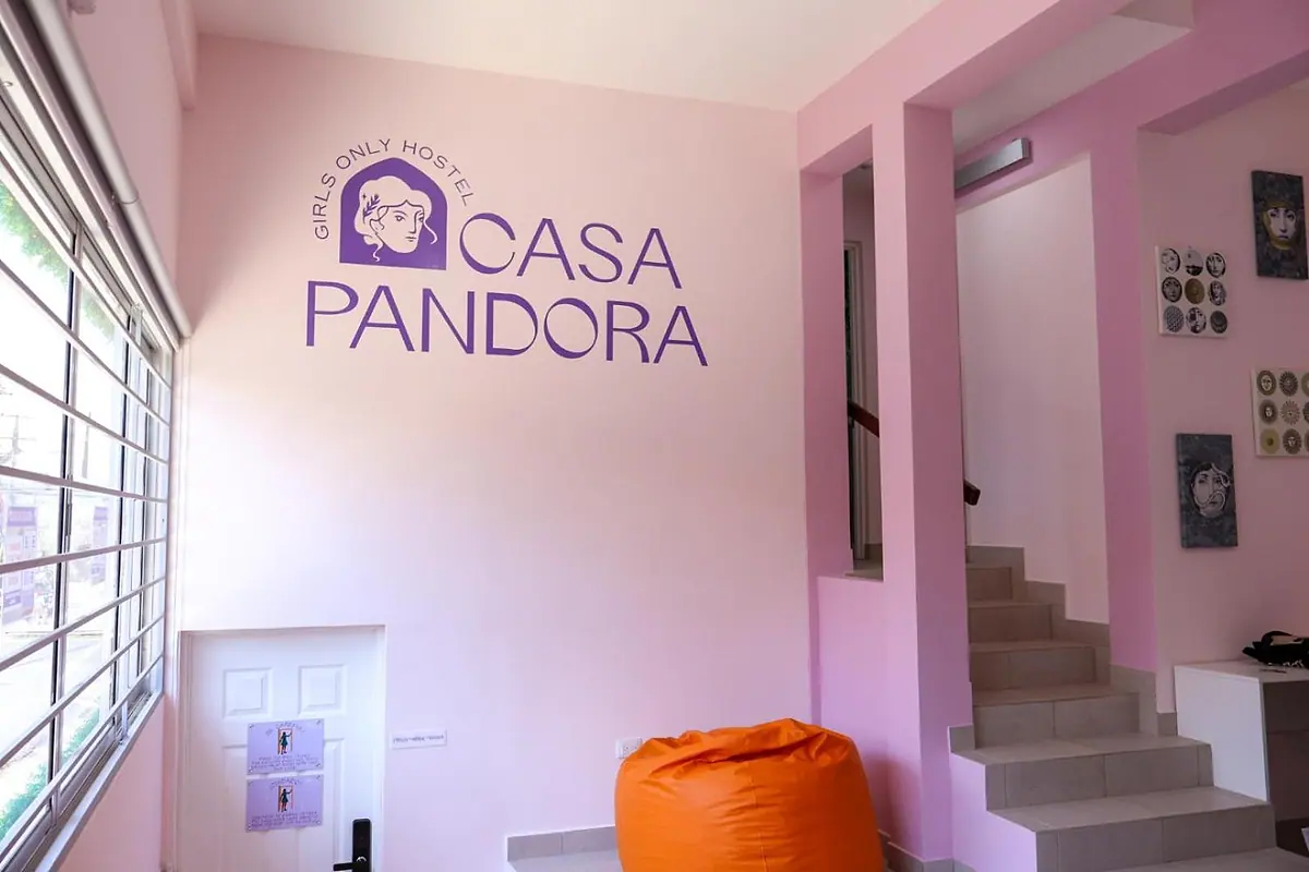 The violet Casa Pandora wall logo above an orange beanbag and the stairs